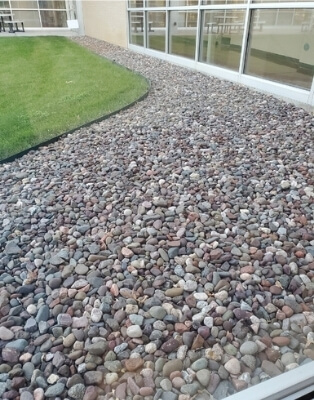 A rock mulch bed bordering a building.